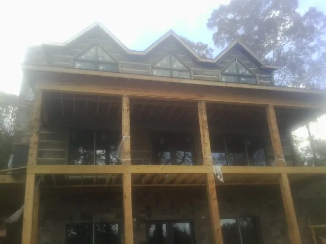 Dormers and porch framing on a large log home under construction — Roof Coating work by our crew in Parker